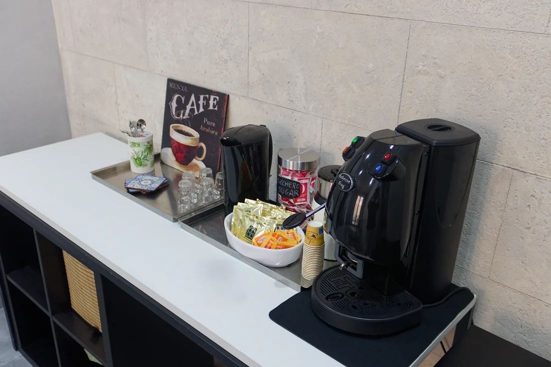 Il vassoio dell'angolo caff&egrave;: le cialde, lo zucchero, le tazzine e la macchina