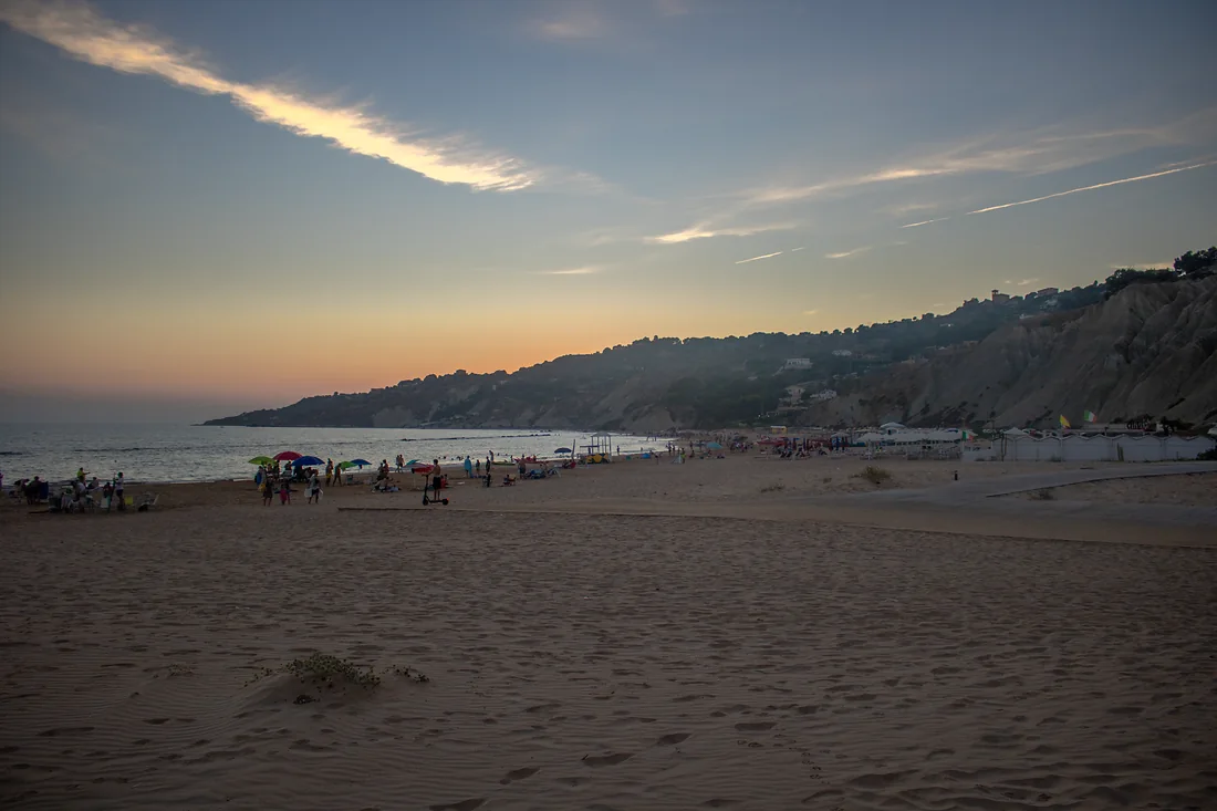 La spiaggia di Marianello al tramonto, con gli ombrelloni aperti e le falesie chiare sullo sfondo